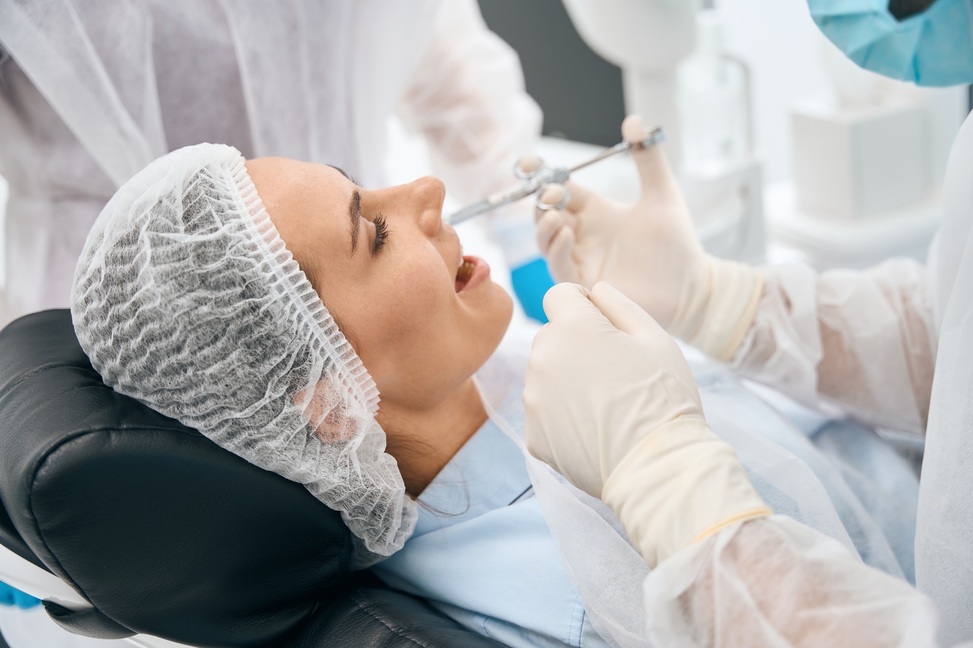 Woman in the dental office receives an injection of painkiller